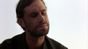 A man with short, dark hair and a beard looks down with a serious, contemplative expression against a pale, plain background—reminiscent of the stoic heroes from rare movies like *Dust (2001) DVD* and other art-house western classics.