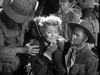 A distressed woman sits with her hand near her mouth as two men in old Western clothing comfort her, evoking the dramatic tension often found in Civil War western tales; several people stand in the background, creating a scene reminiscent of classic moments from the Rocky Mountain (1950) DVD.
