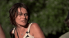 A woman with short dark hair and a beige top stands outdoors, glancing warily to the side amid blurred green foliage—capturing the suspenseful mood of Australian survival horror as seen in “Black Water (2007)” DVD.