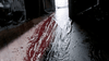 A stream of red liquid, resembling blood, flows across a floor toward an open doorway with light shining in from outside—a scene straight out of the cult classic splatter comedy “Undead (2003),” making this DVD a must-have for fans seeking rare horror movies.