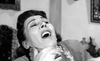 A woman, gripped by terror in a striking black-and-white scene, recoils as hands clasp tightly around her neck—her mouth frozen in a scream and eyes wide with fear. This unforgettable moment is featured in *The Woman Eater (1958)* DVD, making it a must-have for fans of rare hard-to-find movies and British horror DVD collectors alike.