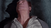 An older man lies on his back on a carpeted floor, gazing upward with a distressed or shocked expression and his shirt slightly open at the collar—an unforgettable moment from The Hidden (1987), a cult 1980s sci-fi action thriller now highly sought after by collectors on DVD.