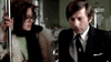 A woman in glasses and a fur coat stands beside a man in a suit and tie on public transport, both with serious expressions—she gazes at him while he looks downward, capturing the tense psychological atmosphere found in Roman Polanski’s films and featured in The Tenant (1976) DVD.