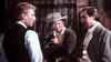 Three men face off indoors: the central figure in a cowboy hat aims a gun at another, as a suited man observes—The Last Gun (1964) DVD is a must-have for Spaghetti Western and classic western enthusiasts.