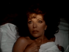 A woman with curly brown hair lies in bed, clutching a white sheet to her chest and looking startled—a dramatic scene from the classic TV miniseries Monte Carlo (1986), available on rare DVD.