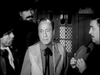 Four men in vintage Western outfits stand indoors, deep in conversation. This black-and-white scene from "The Slowest Gun in the West (1960) DVD" captures the nostalgic charm of classic comedy films.