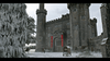 A grand stone castle with towering spires stands amid a wintry landscape blanketed in snow and frost, evoking the magical charm of “The Knight Before Christmas (2019)” DVD. Two horseback riders and a covered wagon make their way toward the entrance, which is decorated with festive red banners. Frosted trees frame the scene in the foreground, setting an enchanting atmosphere perfect for this holiday romance.