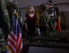 A woman in a red dress stands among military police and soldiers inside a building, evoking the suspense found in the "Breach of Conduct (1994) DVD." An American flag is visible in the foreground near a dark vehicle, enhancing the rare atmosphere of tension reminiscent of scenes from this classic military thriller on DVD.