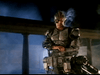 A figure clad in futuristic, heavy armor and a visor stands wielding a massive weapon amid smoky shadows and looming columns—capturing the intense cyborg action vibe of the Eliminators DVD (1986).