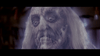 A close-up of a pale, decaying zombie with long gray hair, sunken eyes, and exposed teeth, lit by a bluish light in a dark setting—perfect for fans looking to add “The Frighteners (1996) DVD” to their classic horror collection for an extra chilling touch.