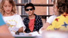 A boy wearing sunglasses and a patterned shirt sits with other children at a table outdoors, looking serious—like the star of Little Monsters (1989) on DVD.