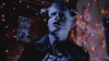 A person with demon-like features and horns looks up in fear, surrounded by colorful string lights against a dark background—a haunting scene reminiscent of cult favorites like *Little Monsters (1989)* on DVD.