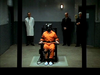 A person in an orange prison jumpsuit sits in an electric chair, surrounded by three men standing in the background inside a dimly lit room, evoking the suspenseful atmosphere of the “Evidence In Blood” DVD (1998).