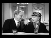 An older man in a suit and an older woman in a flowered hat sit at a table with drinks, smiling at each other in a black-and-white setting—capturing the timeless charm of Make Way For Tomorrow (1937) on DVD.