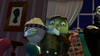An animated green-skinned character sits on a couch, wide-eyed and startled, holding a striped bowl of popcorn while watching “Dear Dracula (2012) DVD,” a Halloween family movie. Popcorn spills onto their lap as they cover their mouth with one hand. The room is dimly lit with curtains behind.