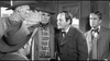 Five men in vintage Western attire engage in a tense discussion indoors, captured in dramatic black and white—evoking classic scenes from the Man With The Gun (1955) DVD.