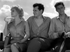 A woman sits between two men in a black and white scene from the Kiss Her Goodbye (1959) DVD.