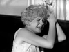 A distressed young woman with curly hair clutches her head and cries in a scene from the movie Kiss Her Goodbye (1959) DVD.
