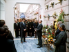 A man in a suit speaks to a group gathered for an indoor mausoleum service as seen in the Murder So Sweet (1993) DVD.