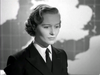 A woman in a military uniform and tie stands in front of a map in a scene from The Cruel Sea (1953) DVD.
