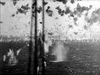 Black-and-white scene from The Cruel Sea (1953) DVD showing a British naval convoy vessel surrounded by explosions and water geysers in the sea.