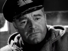 A close-up of a somber naval officer in a peaked cap on The Cruel Sea (1953) DVD cover, evoking the atmosphere of a classic World War II sea drama while looking slightly off-camera.