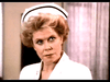 A woman with blond hair and a white nurse hat looks seriously to the side, evoking the senior care drama of classic movies like "Amos (1985)" on DVD.